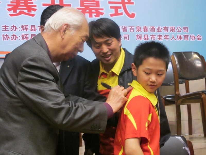 中国乒乓球女队原主教练张燮林在现场为小球迷签字