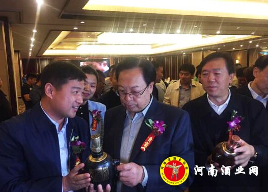 张建设（左）向河南省委原书记徐光春（中）介绍豫坡老基酒